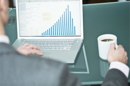 spanish drink - Businessman with coffee cup at laptop with bar chart Stock Photo - Premium Royalty-Free, Code: 644-02923261