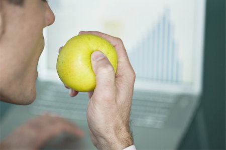 Homme d'affaires eating apple à l'ordinateur portable avec graphique à barres Photographie de stock - Premium Libres de Droits, Code: 644-02923263