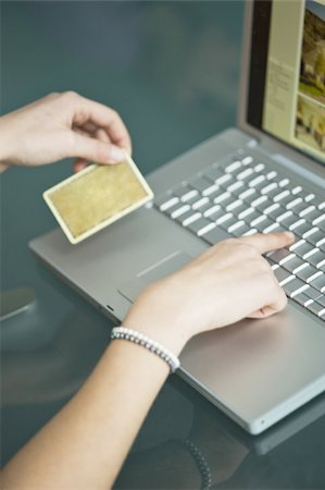 Businesswoman's hands holding credit card at laptop Stock Photo - Premium Royalty-Free, Code: 644-02923297