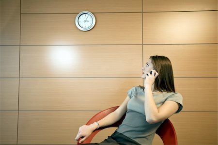 secretary on chair in office - Femme d'affaires téléphone regardant horloge Photographie de stock - Premium Libres de Droits, Code: 644-02923306