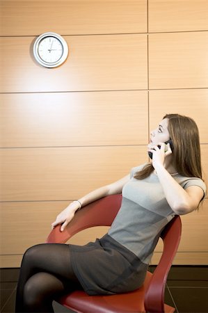 secretary on chair in office - Businesswoman on telephone looking at clock Stock Photo - Premium Royalty-Free, Code: 644-02923303