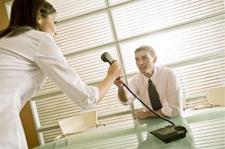 Homme d'affaires donnant le téléphone à la femme d'affaires Photographie de stock - Premium Libres de Droits, Code: 644-02923333