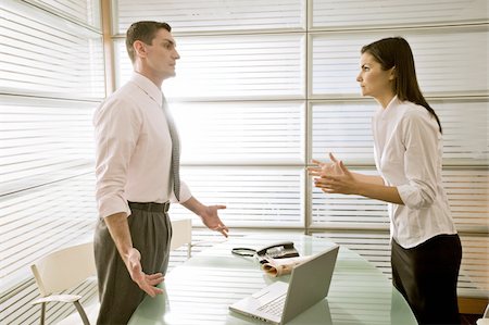 Businessman in office talking to businesswoman Stock Photo - Premium Royalty-Free, Code: 644-02923341