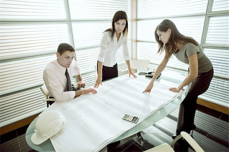 Professionals looking at architectural plans on desk Foto de stock - Sin royalties Premium, Código: 644-02923365