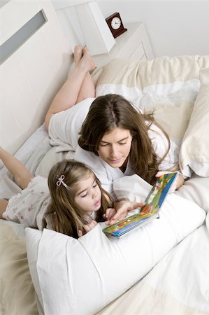spanish mother daughter - Young woman and girl on bed reading a book Stock Photo - Premium Royalty-Free, Code: 644-02923495
