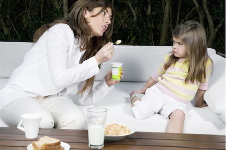 family eating restaurant - Young woman and girl having breakfast outdoors Stock Photo - Premium Royalty-Free, Code: 644-02923524