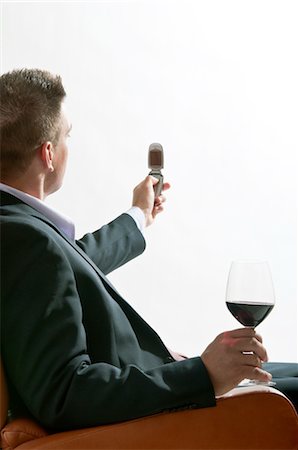 simsearch:644-03405250,k - Jeune homme en costume/tailleur assis avec verre de vin rouge et le téléphone mobile Photographie de stock - Premium Libres de Droits, Code: 644-03405199
