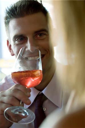 Young man sitting with a glass of orange wine and young woman Stock Photo - Premium Royalty-Free, Code: 644-03405240