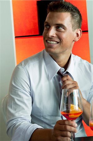 simsearch:644-03405258,k - Jeune homme en complet-veston avec verre de vin orange cravate de réglage Photographie de stock - Premium Libres de Droits, Code: 644-03405265