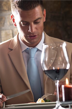 simsearch:644-03405258,k - Jeune homme manger avec verre de vin dans un restaurant Photographie de stock - Premium Libres de Droits, Code: 644-03405341