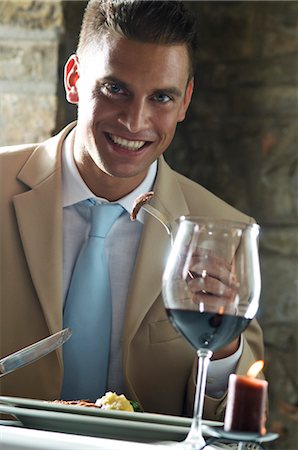 simsearch:644-03405258,k - Jeune homme manger avec verre de vin dans un restaurant Photographie de stock - Premium Libres de Droits, Code: 644-03405343