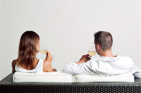 simsearch:644-03405369,k - View of couple from the back sitting on couch drinking white wine Fotografie stock - Premium Royalty-Free, Codice: 644-03405373