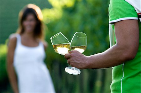 Young woman in vineyard, man bringing glasses of white wine Stock Photo - Premium Royalty-Free, Code: 644-03405479