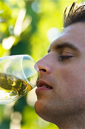 Young man tasting white wine in vineyard Stock Photo - Premium Royalty-Free, Code: 644-03405484