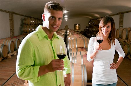 Couple dans une cave à vin avec verres de vin rouge Photographie de stock - Premium Libres de Droits, Code: 644-03405498