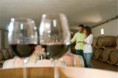 simsearch:862-03354331,k - Couple dans une cave à vin avec verres de vin rouge Photographie de stock - Premium Libres de Droits, Code: 644-03405499