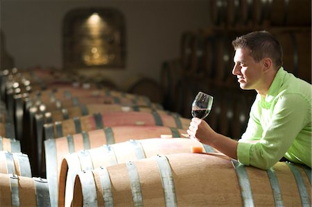 simsearch:862-03354331,k - Jeune homme dans la cave à vin avec verre de vin rouge Photographie de stock - Premium Libres de Droits, Code: 644-03405509