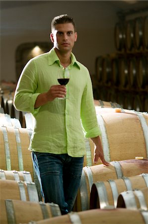 simsearch:862-03354331,k - Jeune homme dans la cave à vin avec verre de vin rouge Photographie de stock - Premium Libres de Droits, Code: 644-03405510