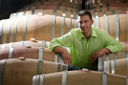 simsearch:862-03354331,k - Jeune homme dans la cave à vin avec des tonneaux en bois Photographie de stock - Premium Libres de Droits, Code: 644-03405511