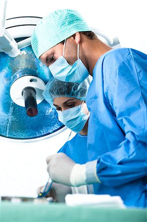 physicians in operating room - Personnel médical en salle d'opération Photographie de stock - Premium Libres de Droits, Code: 644-03659470