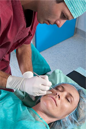 simsearch:644-03659519,k - Surgeon with scalpel to patient's face Stock Photo - Premium Royalty-Free, Code: 644-03659502