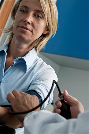 Doctor taking patient's blood pressure Stock Photo - Premium Royalty-Free, Code: 644-03659527