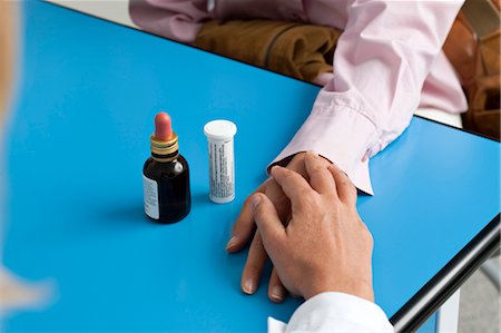 Gros plan des mains du médecin, tenant la main du patient avec la médecine sur table Photographie de stock - Premium Libres de Droits, Code: 644-03659538