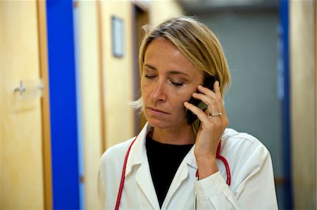 Doctor making telephone call in medical center Stock Photo - Premium Royalty-Free, Code: 644-03659568