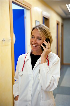 Doctor making telephone call in medical center Stock Photo - Premium Royalty-Free, Code: 644-03659570