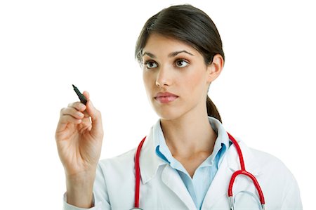 Portrait of female nurse wearing red scrub writing with marker on