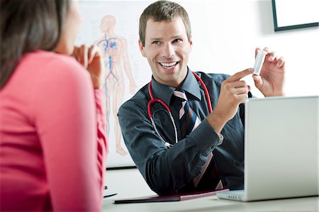 Doctor holding bottle of pills for patient Stock Photo - Premium Royalty-Free, Code: 644-03659681