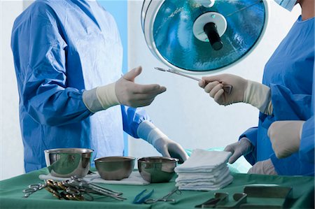 Nurse handing forceps to surgeon in operating room Foto de stock - Sin royalties Premium, Código: 644-03672096