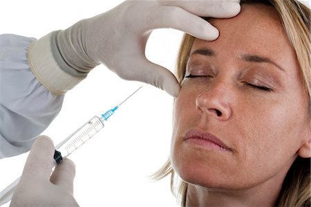 Hand holding botox syringe to woman's face Foto de stock - Sin royalties Premium, Código: 644-03672139