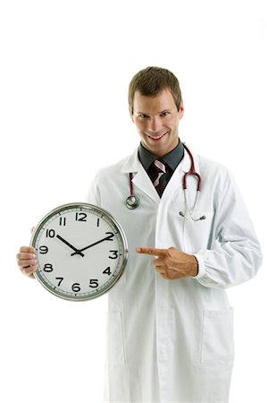 Doctor holding clock showing time Stock Photo - Premium Royalty-Free, Code: 644-03672130