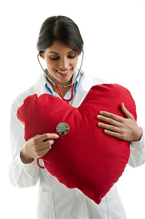 Doctor with stethoscope on heart pillow Stock Photo - Premium Royalty-Free, Code: 644-03672131