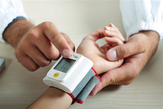 Doctor taking patient's blood pressure Stock Photo - Premium Royalty-Free, Image code: 644-03672142