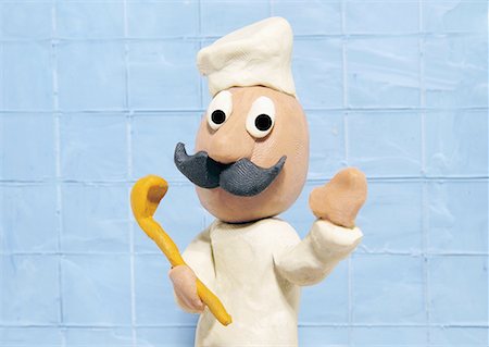 Chef wearing chef's hat and apron holding spoon Stock Photo - Premium Royalty-Free, Code: 645-01826417