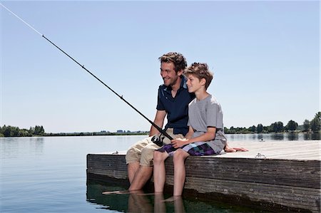 father and son fishing dock lake - Father and son fishing together on dock Stock Photo - Premium Royalty-Free, Code: 649-04247678