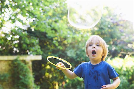 simsearch:649-03770378,k - Boy making oversized bubble in backyard Foto de stock - Sin royalties Premium, Código: 649-04247854