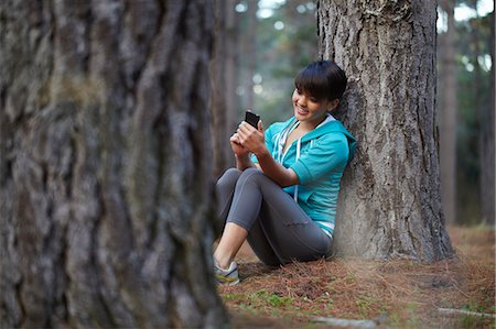 Runner using cell phone in forest Stock Photo - Premium Royalty-Free, Code: 649-04248359