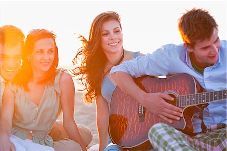 Man playing music for friends on beach Foto de stock - Sin royalties Premium, Código: 649-04248584