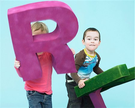 Jeunes enfants jouer avec les lettres surdimensionnés Photographie de stock - Premium Libres de Droits, Code: 649-04248656