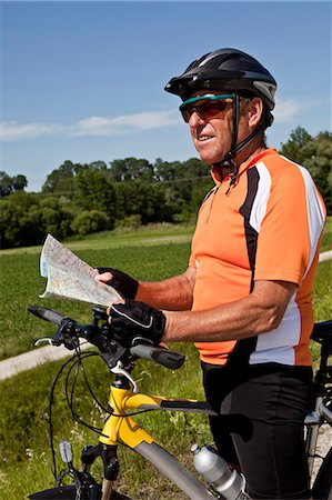 Biker reading map on rural road Stock Photo - Premium Royalty-Free, Code: 649-04248692