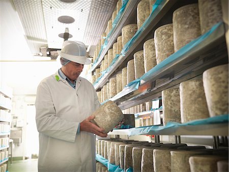 Worker checking blue cheese in factory Stock Photo - Premium Royalty-Free, Code: 649-04248729