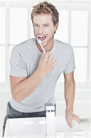 Man brushing his teeth in bathroom Stock Photo - Premium Royalty-Free, Code: 649-04827585