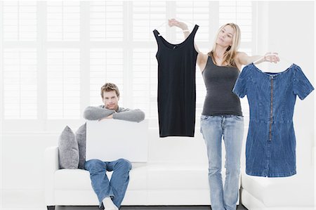 Woman picking out clothes in living room Fotografie stock - Premium Royalty-Free, Codice: 649-04827605