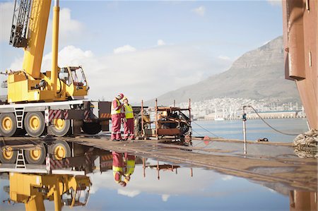 people working on oil rig - Workers on oil rig standing by crane Stock Photo - Premium Royalty-Free, Code: 649-04827641