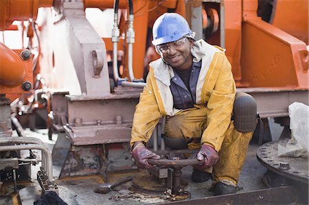 Worker turning wheel on oil rig Foto de stock - Sin royalties Premium, Código: 649-04827659