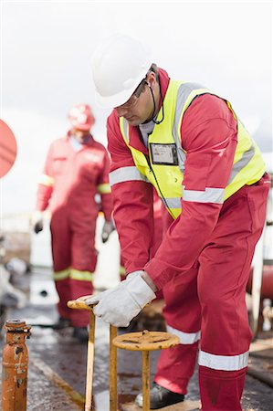 simsearch:649-04827643,k - Worker turning wheel on oil rig Foto de stock - Sin royalties Premium, Código: 649-04827653