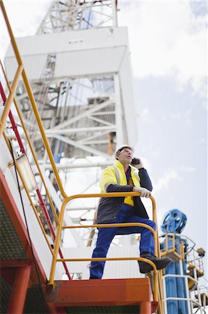 Travailleur parlait au téléphone portable sur la plate-forme de forage pétrolier Photographie de stock - Premium Libres de Droits, Code: 649-04827665